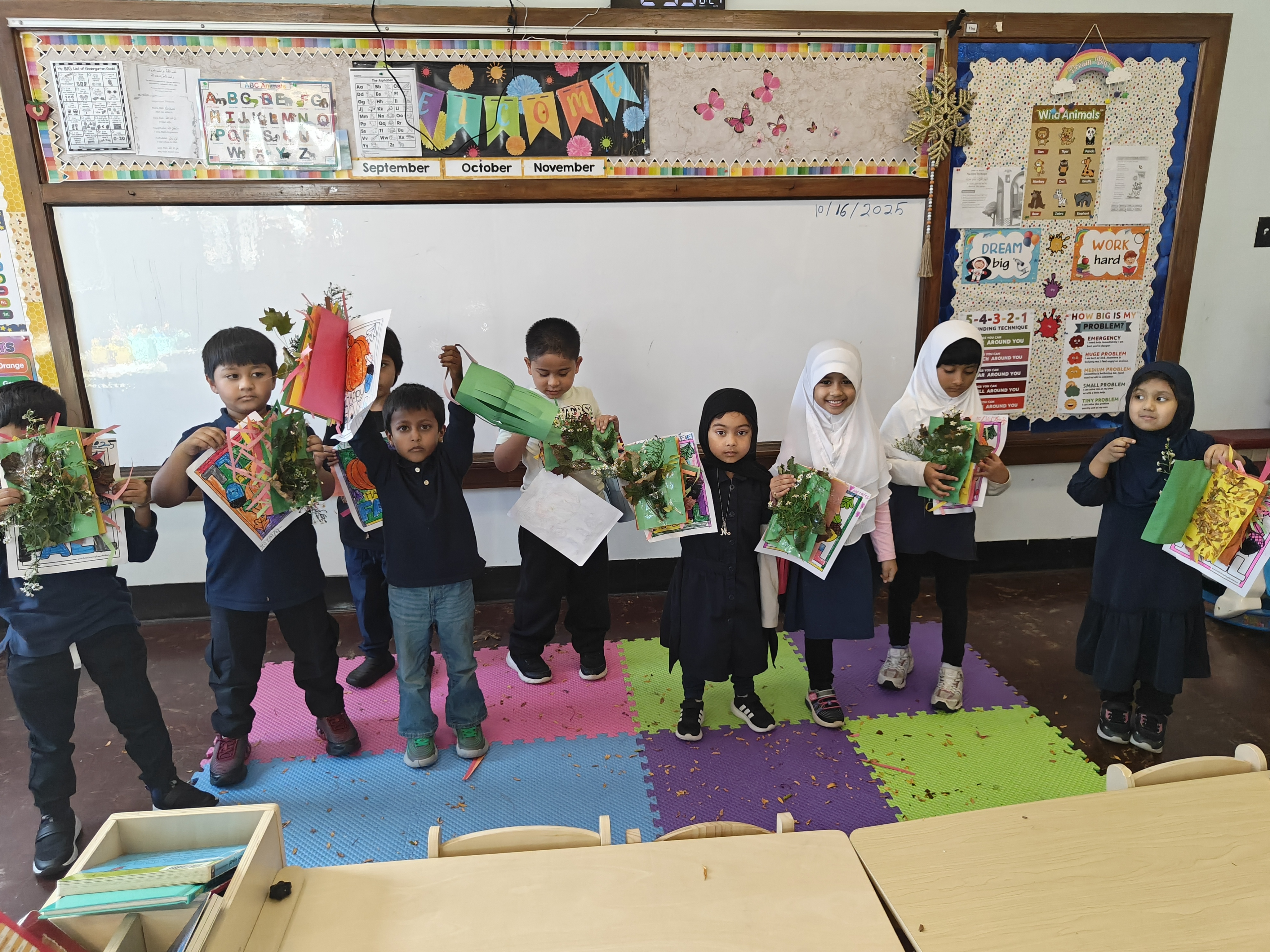 Kindergarteners presenting fall nature crafts